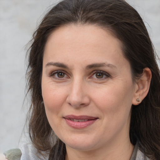 Joyful white adult female with long  brown hair and brown eyes