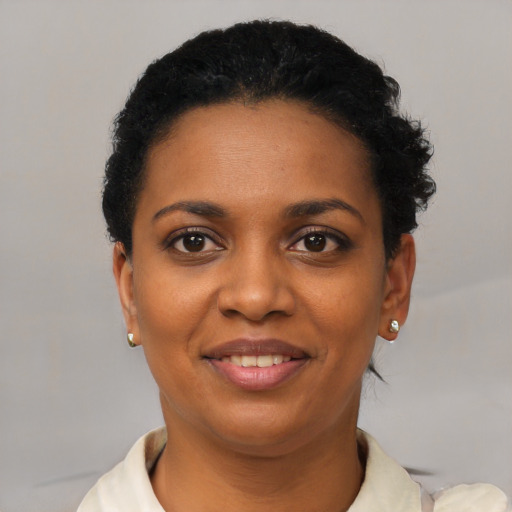 Joyful black young-adult female with short  black hair and brown eyes