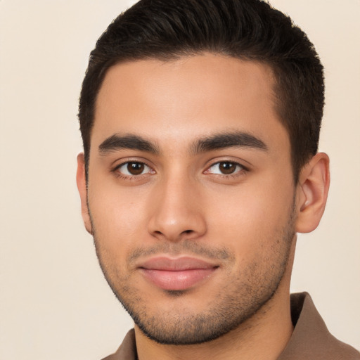 Joyful latino young-adult male with short  brown hair and brown eyes