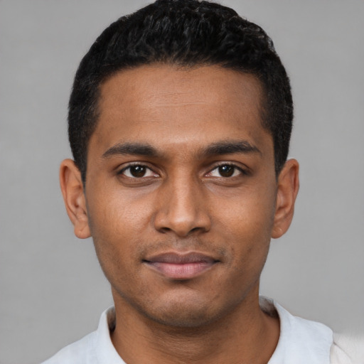 Joyful black young-adult male with short  black hair and brown eyes