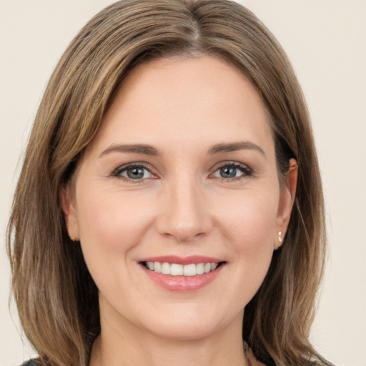 Joyful white young-adult female with medium  brown hair and grey eyes