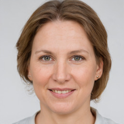 Joyful white adult female with medium  brown hair and grey eyes