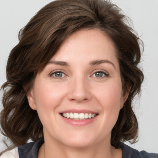 Joyful white young-adult female with medium  brown hair and green eyes