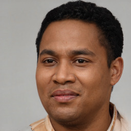 Joyful latino young-adult male with short  black hair and brown eyes