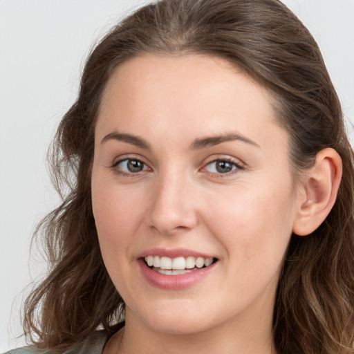 Joyful white young-adult female with long  brown hair and grey eyes