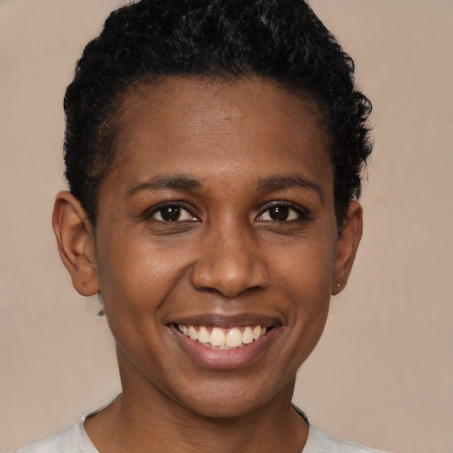 Joyful black young-adult female with short  black hair and brown eyes