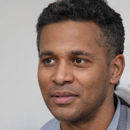 Joyful latino adult male with short  black hair and brown eyes