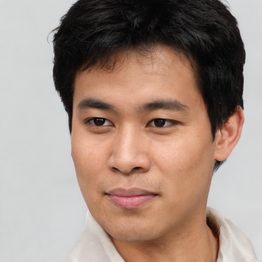 Joyful asian young-adult male with short  brown hair and brown eyes
