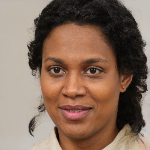 Joyful black adult female with medium  brown hair and brown eyes