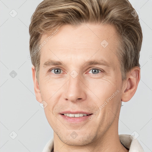 Joyful white adult male with short  brown hair and grey eyes