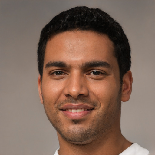 Joyful latino young-adult male with short  black hair and brown eyes