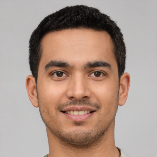 Joyful latino young-adult male with short  brown hair and brown eyes