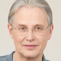 Joyful white middle-aged male with short  gray hair and blue eyes