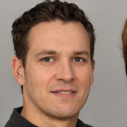 Joyful white adult male with short  brown hair and brown eyes