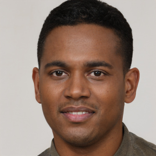 Joyful black young-adult male with short  brown hair and brown eyes