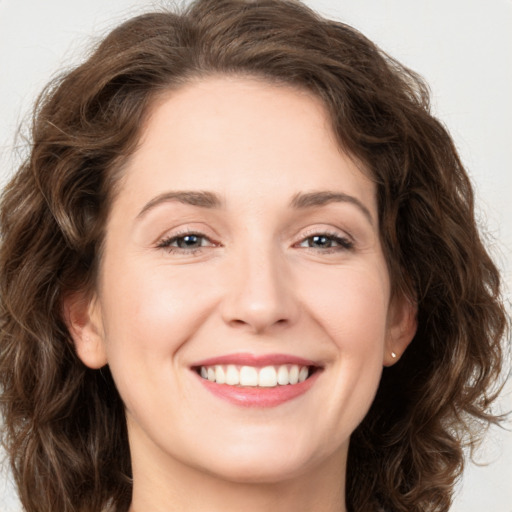 Joyful white young-adult female with long  brown hair and green eyes