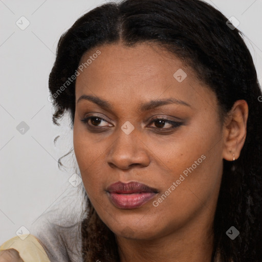 Joyful black young-adult female with long  brown hair and brown eyes