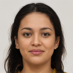 Joyful latino young-adult female with long  brown hair and brown eyes