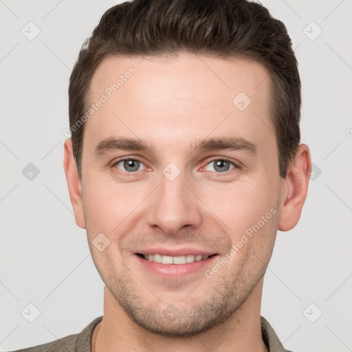 Joyful white young-adult male with short  brown hair and grey eyes