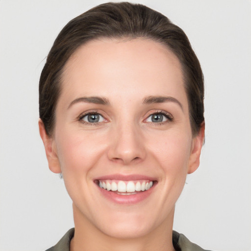 Joyful white young-adult female with short  brown hair and grey eyes