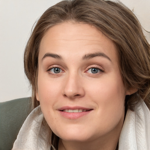 Joyful white young-adult female with medium  brown hair and blue eyes