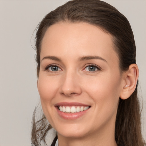 Joyful white young-adult female with long  brown hair and grey eyes