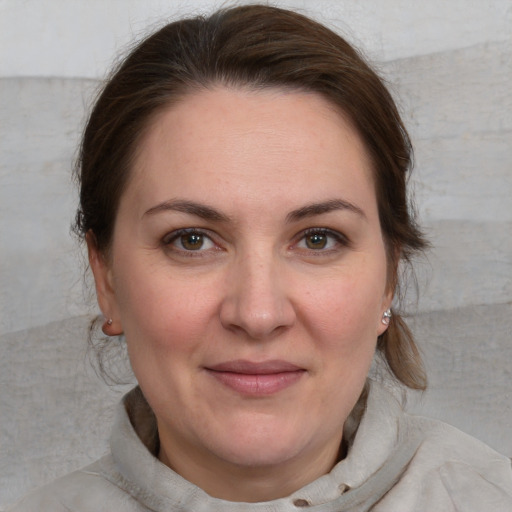 Joyful white adult female with medium  brown hair and blue eyes