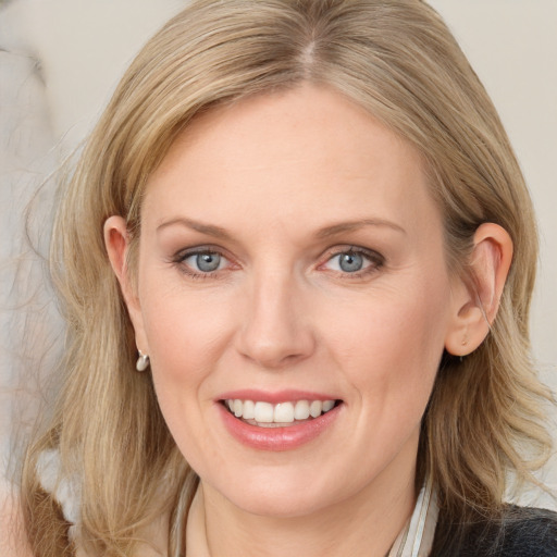 Joyful white adult female with long  brown hair and blue eyes