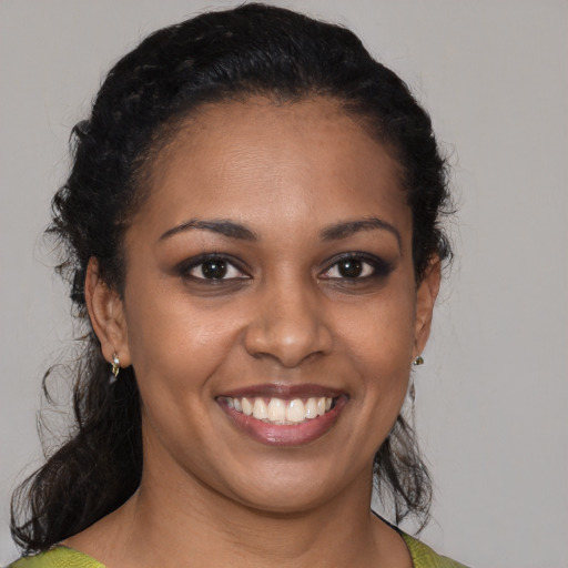 Joyful black young-adult female with medium  brown hair and brown eyes