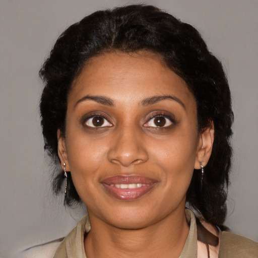 Joyful black young-adult female with short  black hair and brown eyes