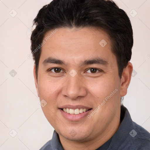 Joyful white young-adult male with short  brown hair and brown eyes