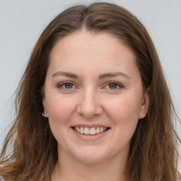 Joyful white young-adult female with long  brown hair and grey eyes