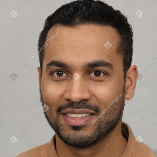 Joyful latino young-adult male with short  black hair and brown eyes