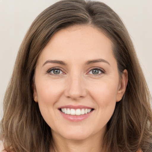 Joyful white young-adult female with long  brown hair and brown eyes