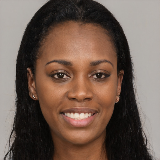 Joyful black young-adult female with long  black hair and brown eyes