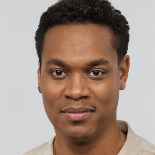 Joyful black young-adult male with short  black hair and brown eyes