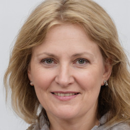 Joyful white adult female with medium  brown hair and grey eyes