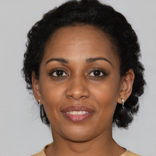 Joyful black young-adult female with medium  black hair and brown eyes