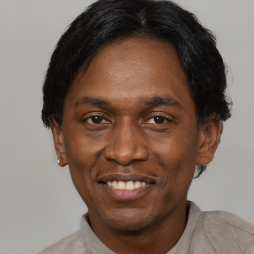 Joyful black adult male with short  black hair and brown eyes