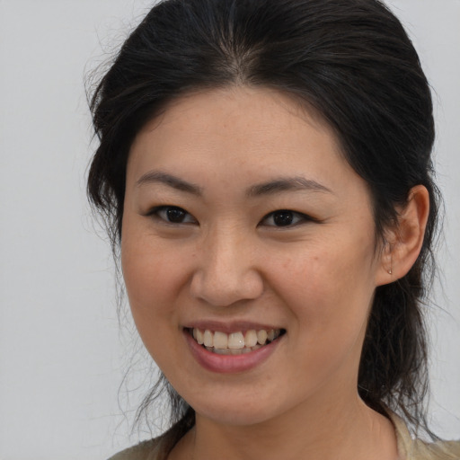 Joyful asian young-adult female with medium  brown hair and brown eyes