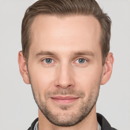 Joyful white young-adult male with short  brown hair and grey eyes