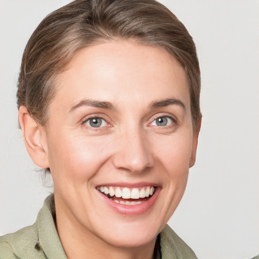 Joyful white young-adult female with medium  brown hair and grey eyes