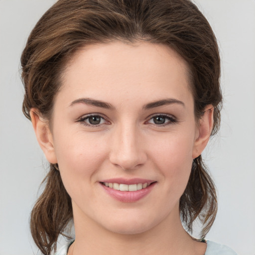 Joyful white young-adult female with medium  brown hair and grey eyes