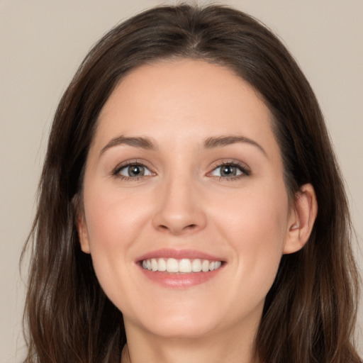 Joyful white young-adult female with long  brown hair and brown eyes