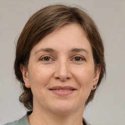 Joyful white adult female with medium  brown hair and grey eyes