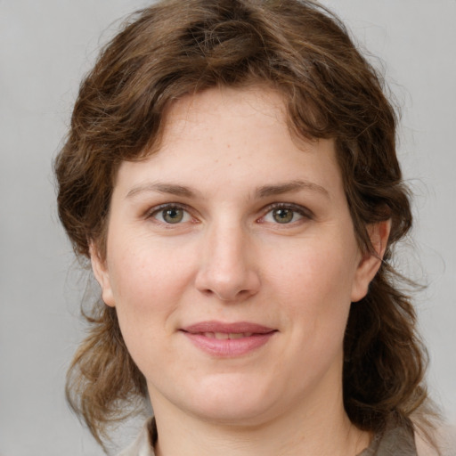 Joyful white young-adult female with medium  brown hair and green eyes