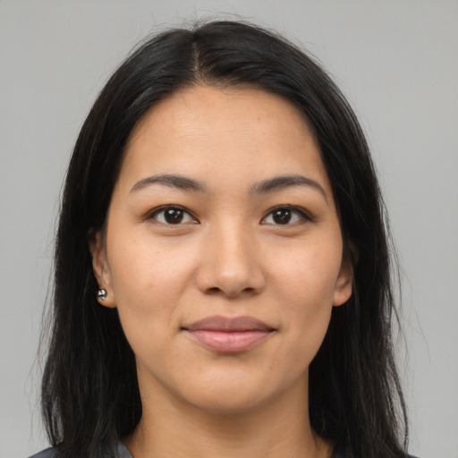 Joyful latino young-adult female with long  brown hair and brown eyes