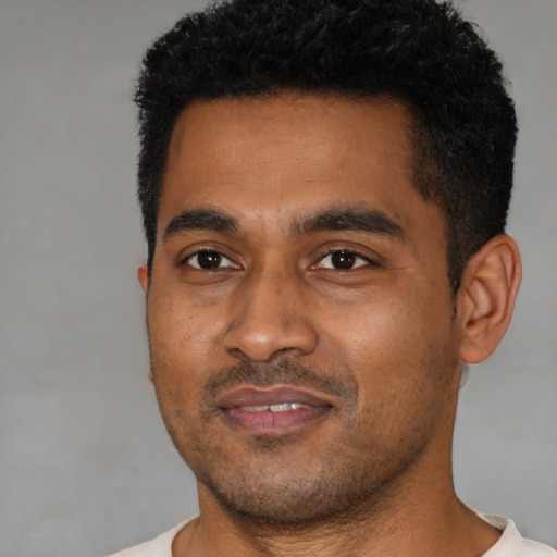 Joyful black young-adult male with short  black hair and brown eyes