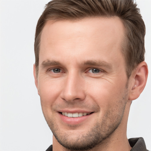 Joyful white young-adult male with short  brown hair and grey eyes