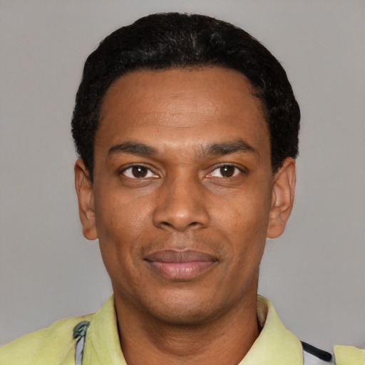Joyful black young-adult male with short  black hair and brown eyes